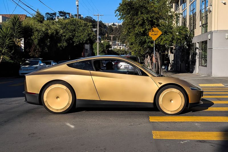 A gold Tesla Cybercab driving down Harrison Street in San Francisco