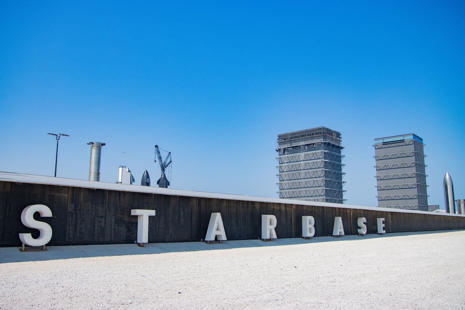 The Starbase sign and launch towers at SpaceX's Starbase site in South Texas